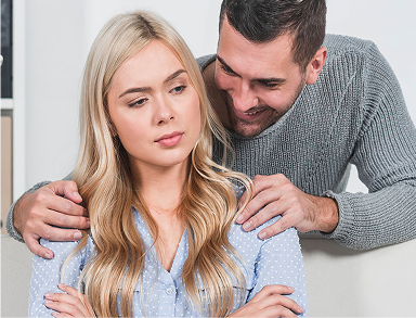 Man comforting a woman who looks upset or thoughtful.