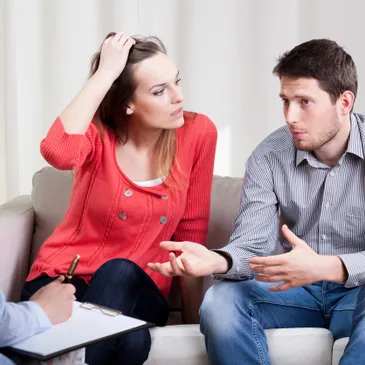 Couple having a serious discussion on a couch.
