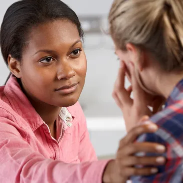 Woman comforting another woman during a heartfelt conversation.