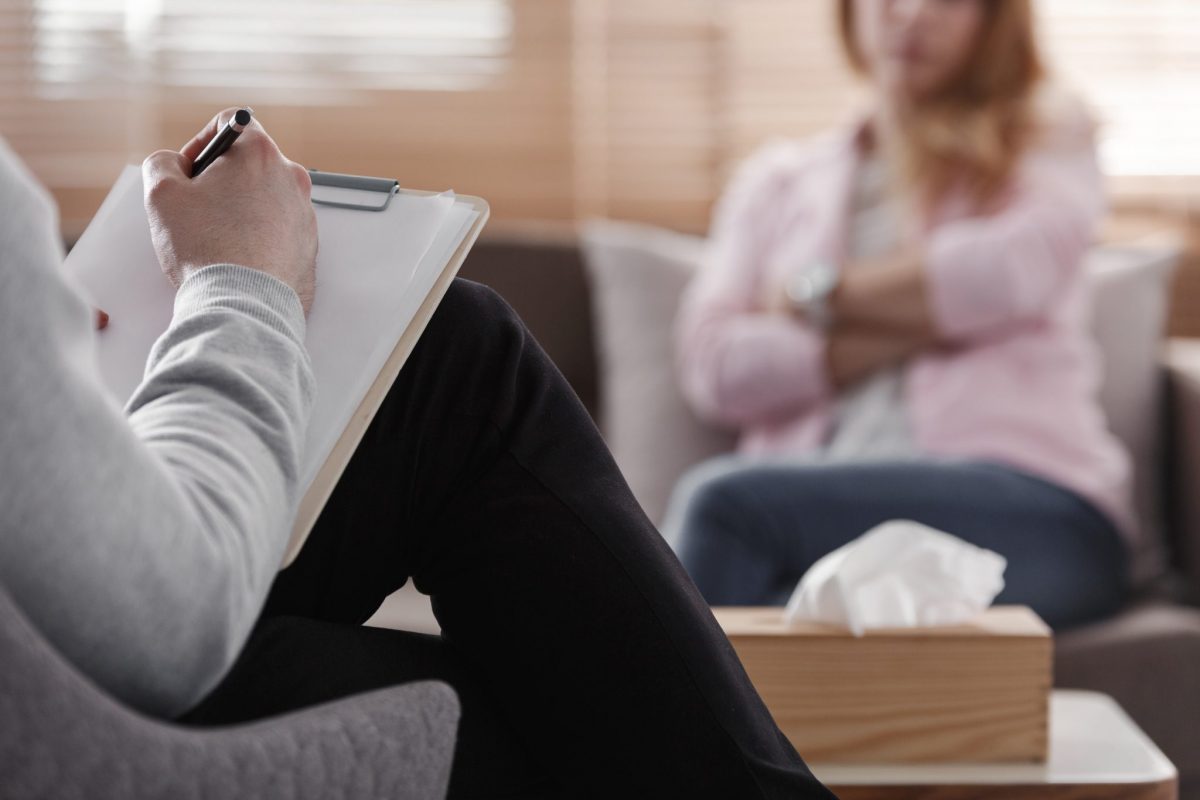 Therapist taking notes during a counseling session with a patient. Therapist taking notes during a counseling session with a patient.